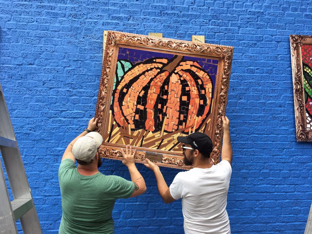 A couple of men standing next to a blue wall